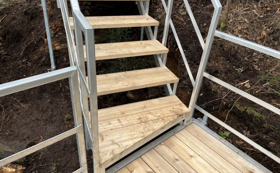 Escalier en forêt avec rampe en métal